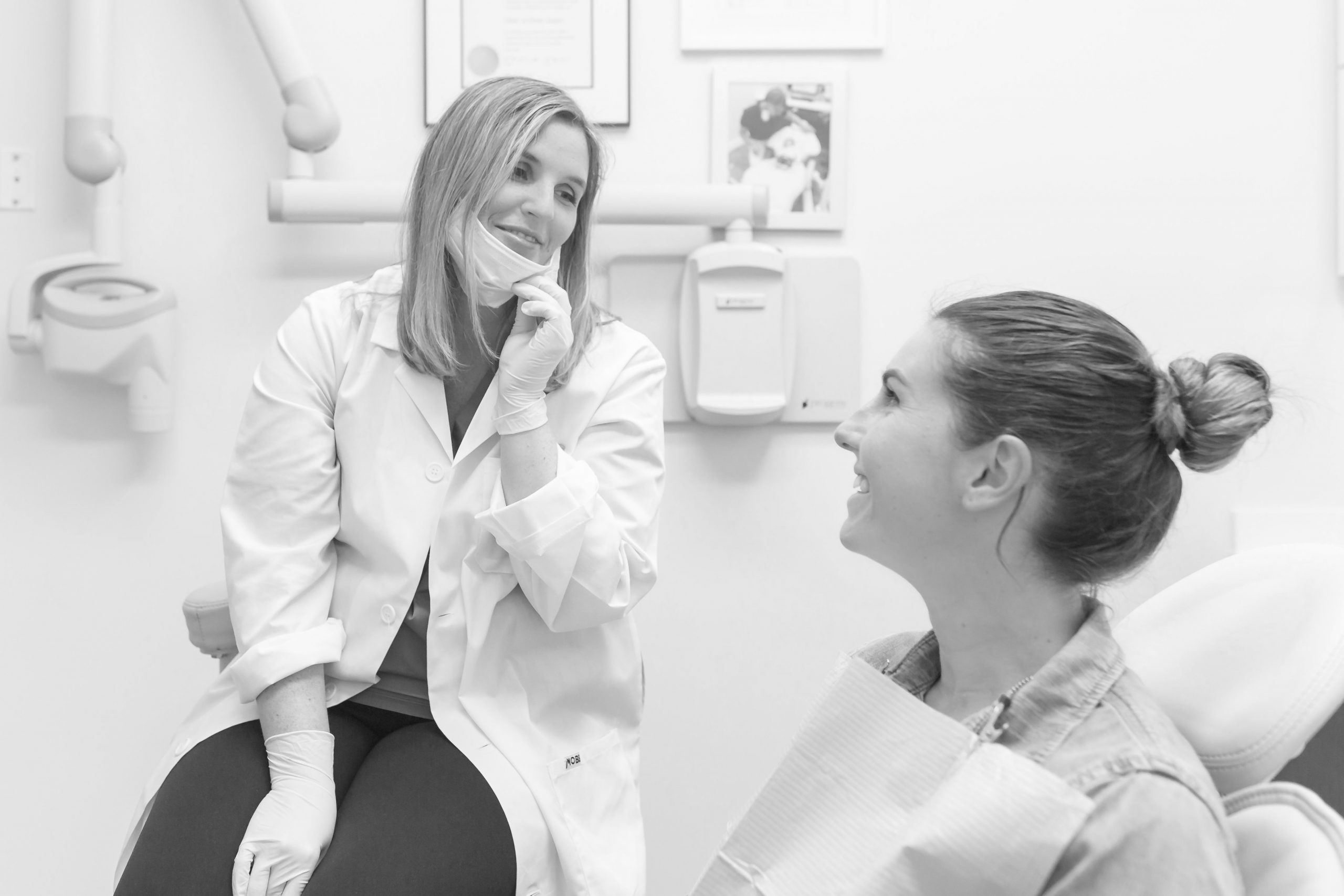 Female Dentist talking to female patient-dark gray